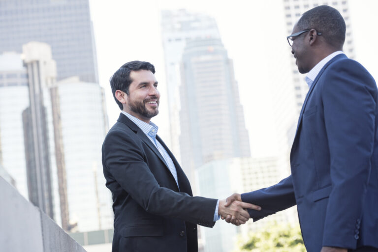 Two businessmen shaking hands in the city
